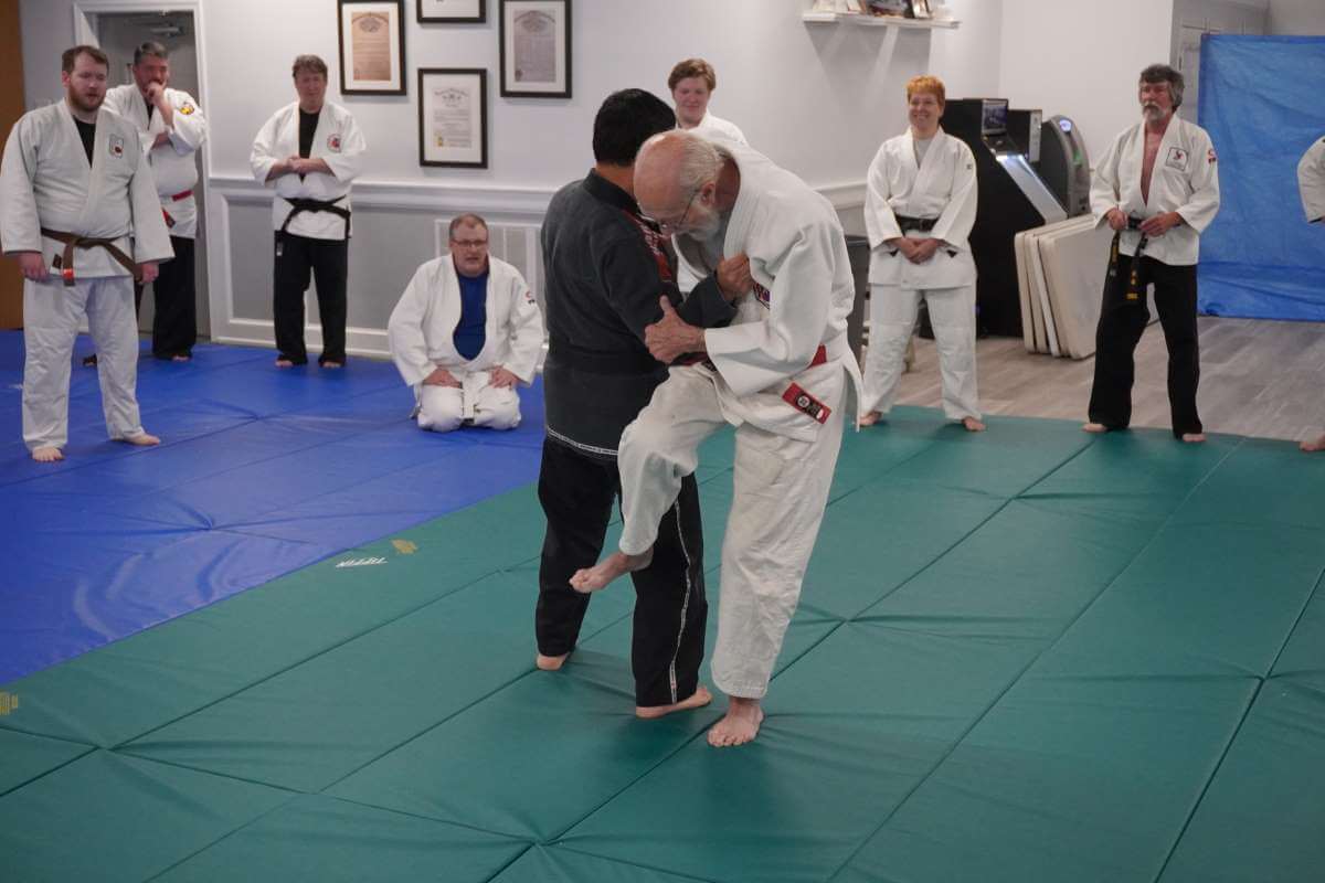 Sensei David Boesel (right) talking about and demonstrating where the sweeping leg goes with Young Kim (left).