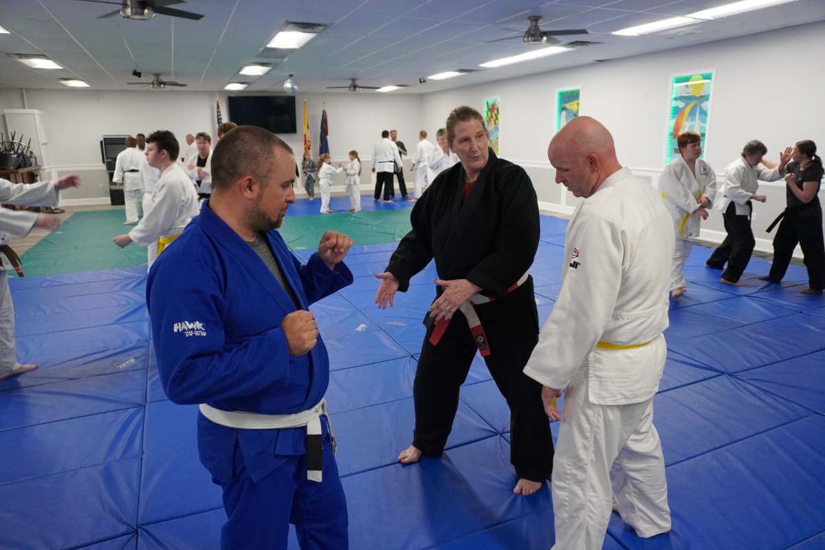 Sensei Debbie Burk (Center) talking about foot placement for a block with Dominic Russo (left) and Christopter Lewis (Right).