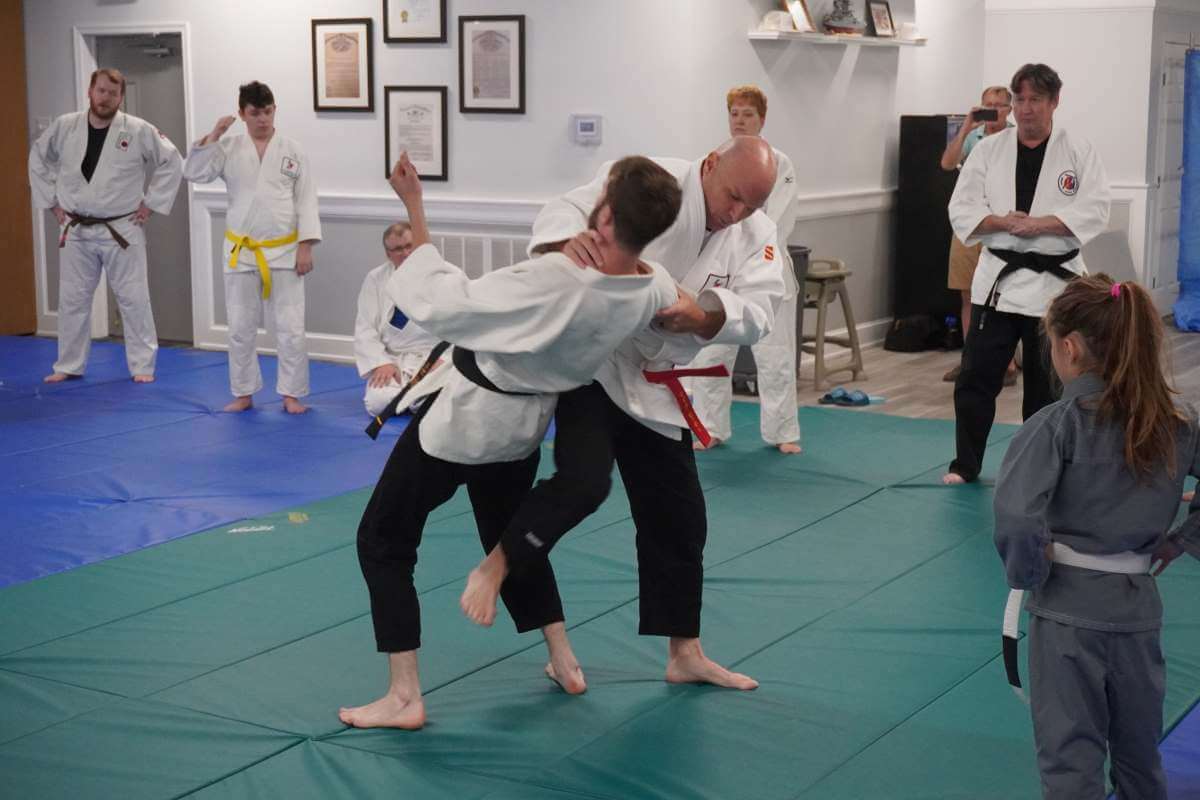 Sensei Mike Hickey (right center) performing a neck sweep with his partner Zion Coldiron (left center).