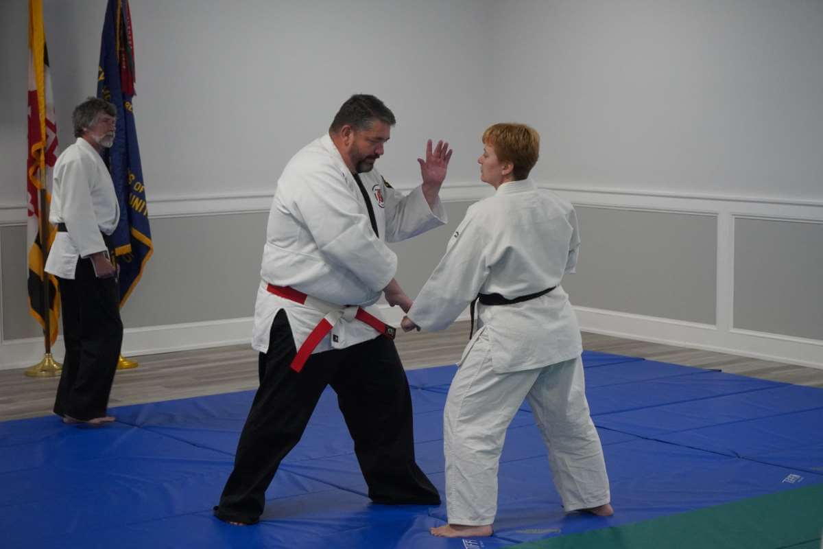Sensei Will Harris (left) demonstrating hand placement from advancing attack with (Joni Peebles, right).
